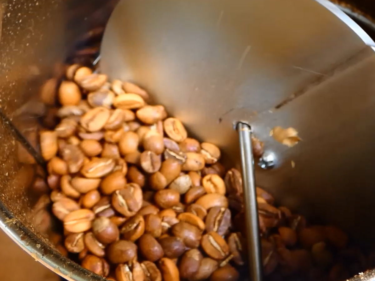 A screenshot of Larry Cotton's EZ Wobble Disk Home Coffee Roaster in action. The disk is scooping up roasted beans to agitate the batch.